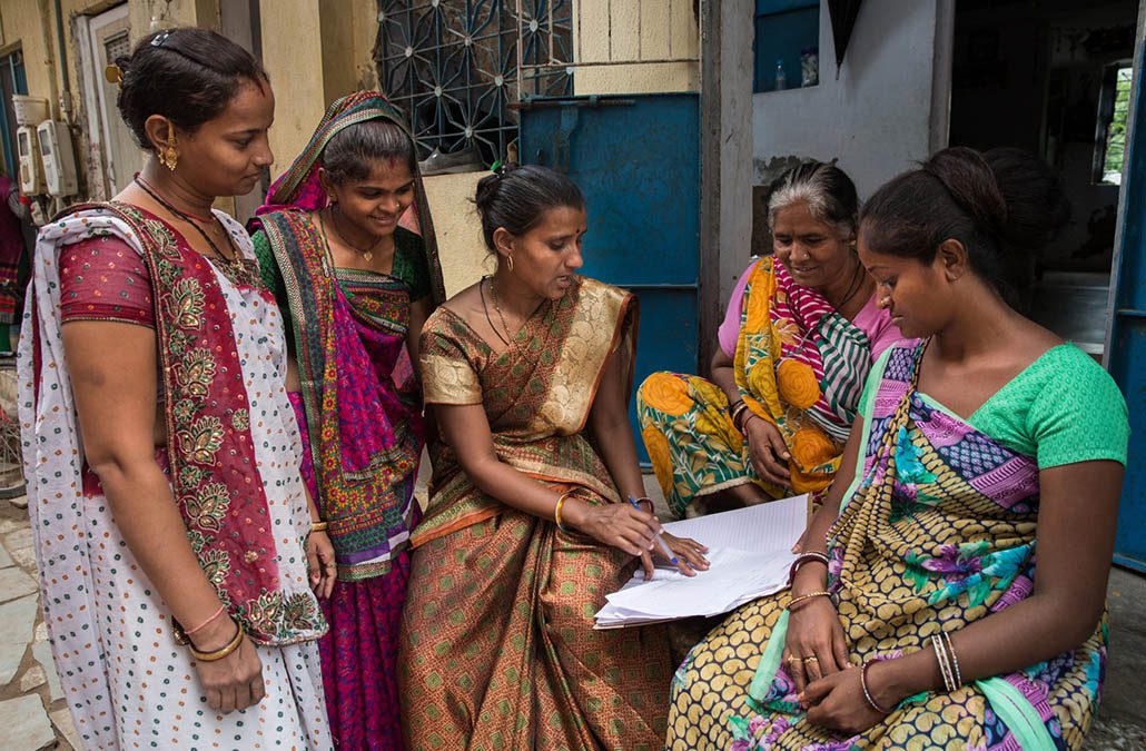 Female neighbors in Gujarat, India gather outside their homes