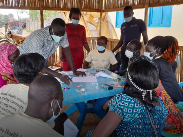 People gather around a table during the design and test phase in South Sudan