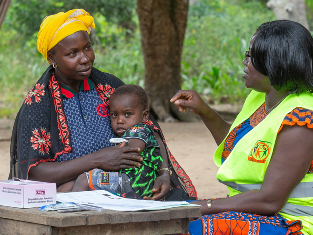 A mother and her 2 year old son are attended to by a community health volunteer in Cote d'Ivoire