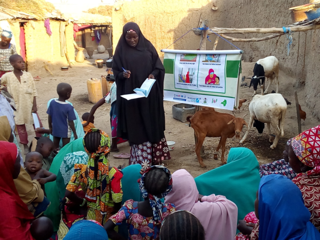A woman leads a compound meeting in northern Nigeria.