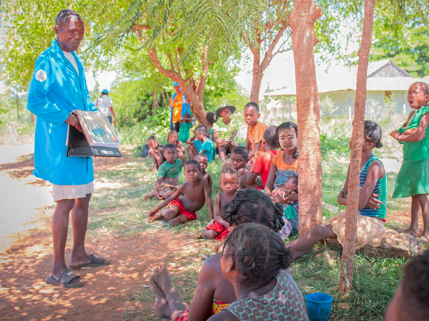 A male community health volunteer conducts a mass education session on the use of mosquito bed nets in Madagascar