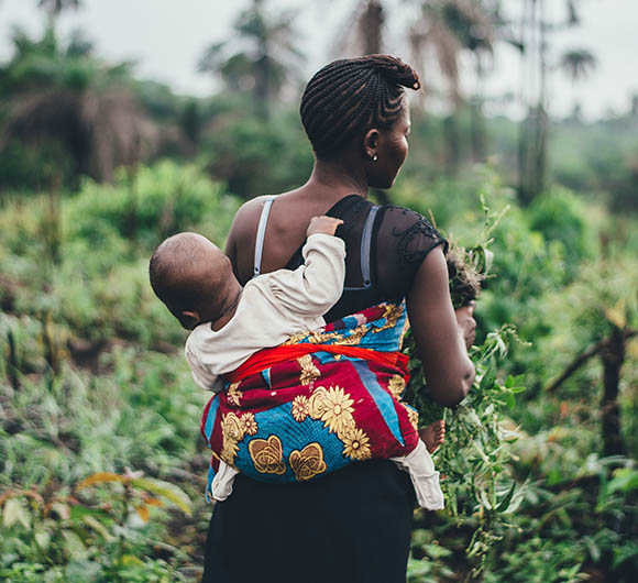 a woman carrying her baby in a sling