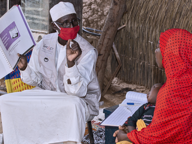 A male community health worker in Niger talks with a mother about the best ways to protect herself and her family from malaria