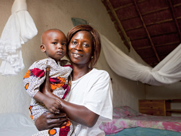 A Senegalese mother and child with knotted bed nets in the background