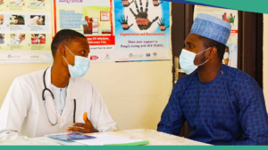 Male healthcare worker counseling male patient in a vaccination clinic